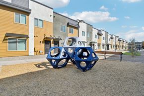 Tolleson apartment for rent - A playground with a blue structure in front of apartment buildings.