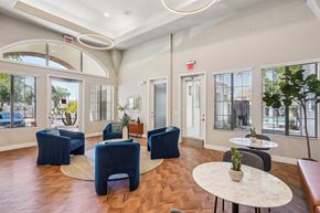 Phoenix apartment for rent - A spacious room with blue chairs and a white table.