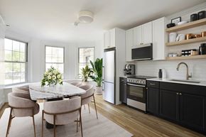 Brookline apartment for rent - Modern kitchen and dining area with marble table, pink chairs, and stainless steel appliances.