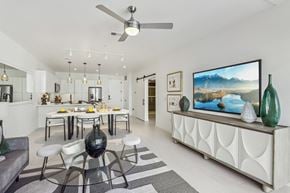 Las Vegas apartment for rent - A modern dining room with a glass table and white chairs.
