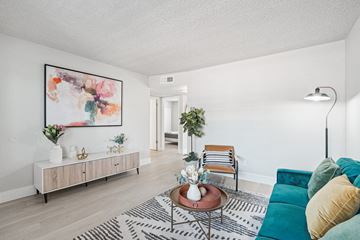 Phoenix apartment for rent - A living room with a green couch and a painting on the wall.