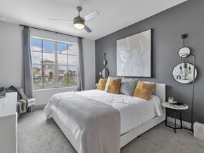 Las Vegas apartment for rent - A bedroom with a large bed and a view of a building outside the window.
