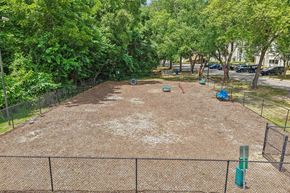 Raleigh apartment for rent - A tennis court surrounded by a fence and trees.