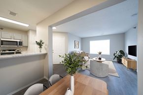 Olathe apartment for rent - A modern kitchen with a dining table and chairs.