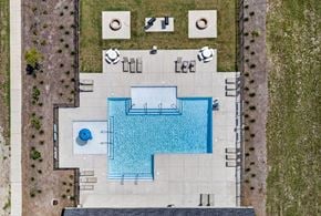North Charleston apartment for rent - An aerial view of a pool surrounded by a concrete patio and a grassy area.