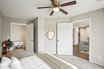 Olathe apartment for rent - A living room with a white couch and a ceiling fan.