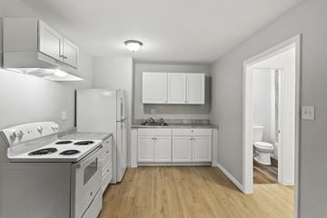 Macon apartment for rent - A white kitchen with a stove top oven and a refrigerator.