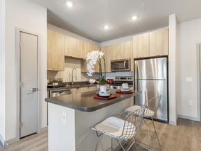 Las Vegas apartment for rent - A kitchen with a refrigerator, sink, and a dining table with chairs.