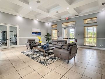 Lauderhill apartment for rent - A spacious living room with a large grey sofa set and a coffee table in the center.