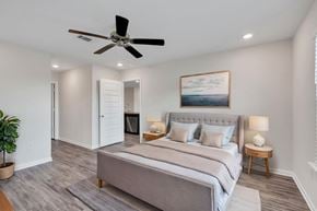 Ocean Springs apartment for rent - A bedroom with a large bed and a ceiling fan.