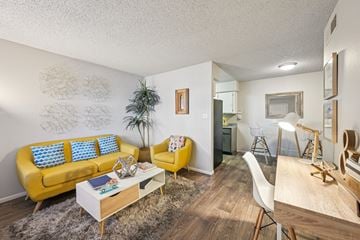 Mesa apartment for rent - A living room with a yellow sofa and a white coffee table.