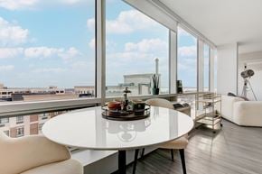 New Rochelle apartment for rent - A modern dining room with a table set for two and a view of the city.