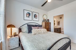 Hutto apartment for rent - A bedroom with a large bed and a lamp on a side table.