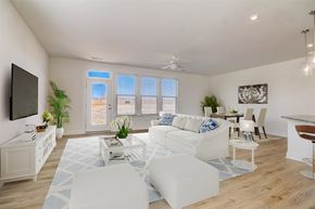 Sherrills Ford townhouse for rent - Sherrills Ford, NC, Townhomes Near Carowinds - Montera at Sherrills Ford - A Living Room with White Sofa, Large Windows, and a Mounted TV on the Wall.