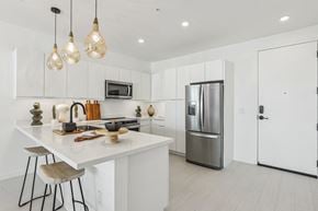 Las Vegas apartment for rent - A modern kitchen with white cabinets and a white island.