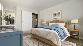 Aurora apartment for rent - A bedroom with a bed, a nightstand, and a vase of flowers.