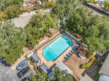 San Antonio apartment for rent - An aerial view of a swimming pool surrounded by trees and a parking lot.