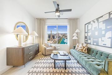 Las Vegas apartment for rent - A living room with a green couch and a large window with a view of the city.