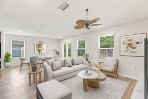Pensacola apartment for rent - A living room with a grey sofa, wooden coffee table, and a ceiling fan.