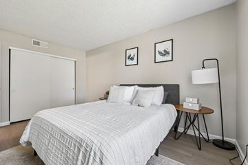 Tempe apartment for rent - A bedroom with a white bed and a black headboard.