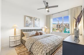 Las Vegas apartment for rent - A bedroom with a large bed and a view of the city.