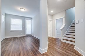 Houston townhouse for rent - an empty living room with wood flooring and a staircase