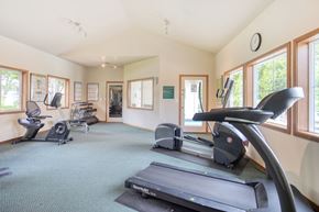 University Place apartment for rent - Garden-Style Apartments in University Place, WA, with In-Unit Washer and Dryer - Carriage House - Fitness Center With Treadmills, Stationary Bike, Weight Bench, Dumbbells, and Large Windows.