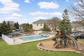 Burnsville townhouse for rent - A playground with a slide and a pool in the background.