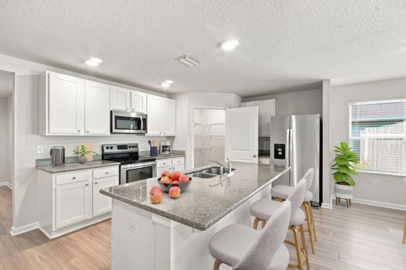 Pensacola apartment for rent - A kitchen with a granite countertop and white cabinets.
