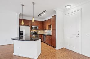 Houston apartment for rent - A kitchen with wooden cabinets and a black countertop.