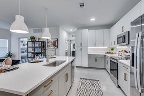 Austin apartment for rent - A modern kitchen with white cabinets and appliances.