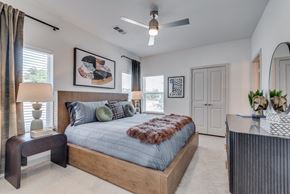Austin apartment for rent - A bedroom with a large bed and a ceiling fan.