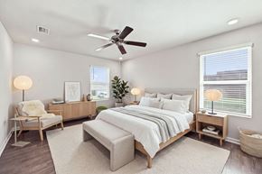 Foley apartment for rent - A bedroom with a large bed, a chair, and a ceiling fan.