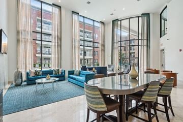 Houston apartment for rent - A modern living room with a glass table and blue couches.