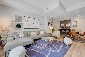 Las Vegas apartment for rent - A living room with a grey sofa and a blue rug.