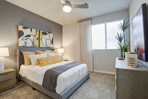Scottsdale apartment for rent - South Scottsdale Apartments - Lucent Scottsdale - Spacious Bedroom With Carpeted Flooring, Bed, Side Tables With Lamps, Dresser, Ceiling Fan, And A Window With Blinds