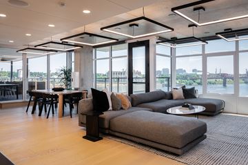 Portland apartment for rent - A modern living room with a large grey sofa and a view of the city.