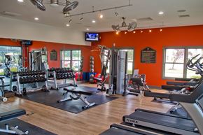 Raymore apartment for rent - A gym with orange walls and a variety of equipment.