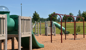Olympia apartment for rent - A playground with a green slide and a red swing set.