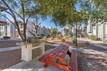 Henderson apartment for rent - a picnic table and barbecue grill in a park with trees