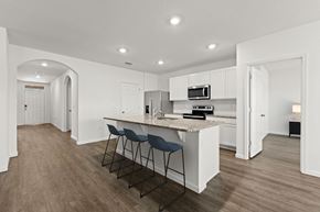 Palm Bay townhouse for rent - A kitchen with white cabinets and a countertop with a bar stool.