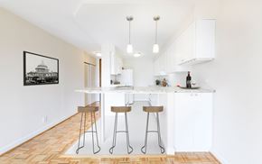 Washington apartment for rent - A kitchen with white cabinets and a framed picture of a building on the wall.