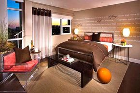 Irvine apartment for rent - Dog-Friendly Apartments in Irvine, CA - Astoria at Central Park West - Modern Bedroom With Plush Bed, Typography Accent Wall, Side Lamps, Armchair, Bed Bench, and Large Corner Windows.