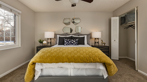 Aurora apartment for rent - A bedroom with a bed covered in a yellow comforter.