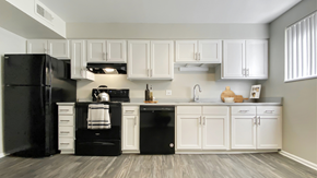 Aurora apartment for rent - A black refrigerator and oven in a kitchen with white cabinets.