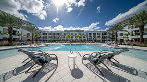 Oviedo apartment for rent - a swimming pool with lounge chairs in front of an apartment building