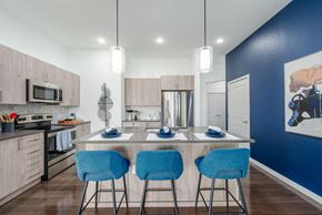 Oviedo apartment for rent - a kitchen with a large island with three blue chairs