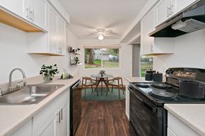 Everett apartment for rent - a kitchen with white cabinets and a dining room with a table