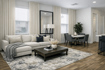 Las Vegas townhouse for rent - A modern living room with a white sofa, a coffee table, and a dining table set up.