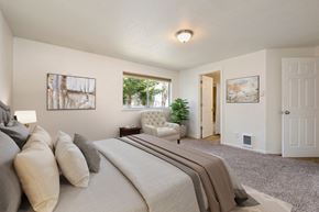 Lynnwood apartment for rent - Lynnwood, WA, Apartments For Rent - Evergreen Grove Apartment Homes - Bedroom With Carpet Flooring, Bed, Couch, Side Table, Paintings, Lamp, And Large Windows.